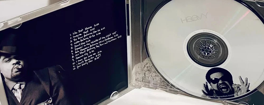 Open CD case showing a CD and album art featuring a black and white image of a man in a suit and hat.